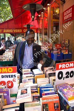 Customer shopping at a bookstore along Boulevard Saint-Michel in the Latin Quarter of Paris, France.