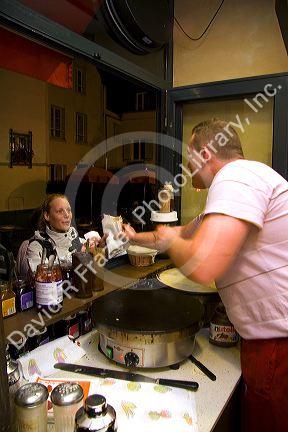French man making crepes at a Creperie in the Montmartre District of Paris, France.