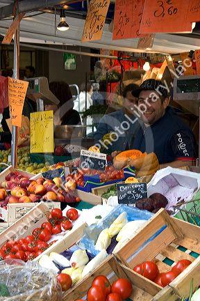 People shopping for produce at an outdoor Saturday market in Paris, France.