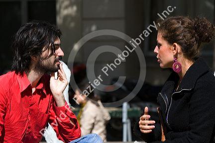 French man and woman have a conversation near the Sorbonne in Paris, France.