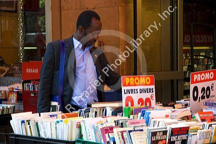 Customer shopping at a bookstore along Boulevard Saint-Michel in the Latin Quarter of Paris, France.