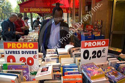 Customer shopping at a bookstore along Boulevard Saint-Michel in the Latin Quarter of Paris, France.