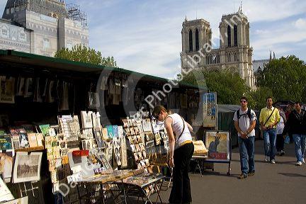 Street vendor in front of the western facade of the Notre Dame de Paris, France.