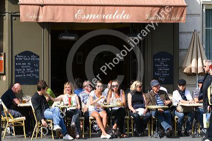 People dine outdoors at a sidewalk cafe in Paris, France.