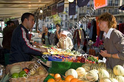 People shopping for produce at an outdoor Saturday market in Paris, France.