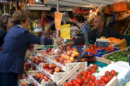 People shopping for produce at an outdoor Saturday market in Paris, France.