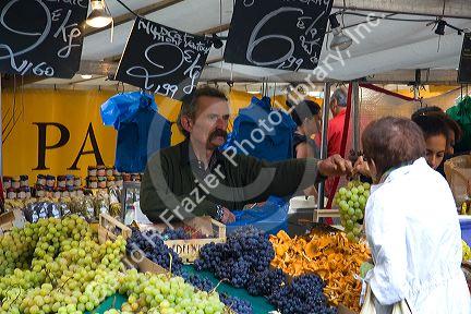 People shopping for produce at an outdoor Saturday market in Paris, France.