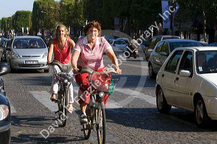 People ride bicycles along the Avenue des Champs-Elysees in Paris, France.
