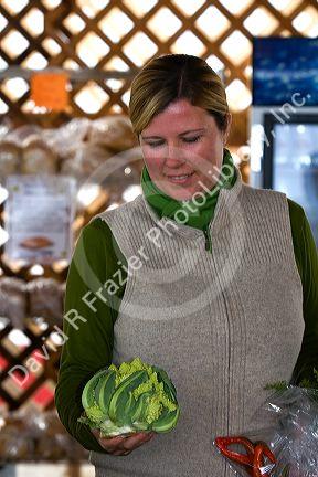 Woman holding a Romanesco broccoli at a farmers market in Fruitland, Idaho. MR