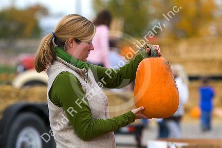 Woman shopping for pumpkins at a farmers market in Fruitland, Idaho. MR