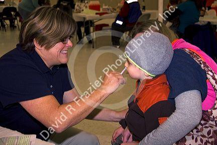 Health care professional administering the nasal spray H1N1 influenza vaccine to a child in Boise, Idaho.