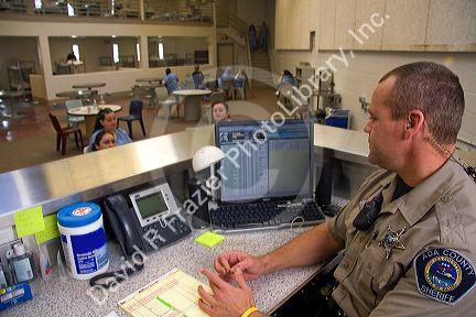 Security officer monitoring the female inmate dormatory of a county jail.