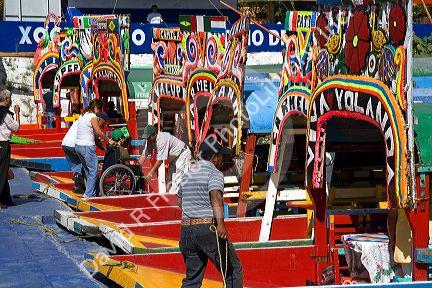 Colorful trajineras travel on the Xochimilco canals within Mexico City, Mexico.