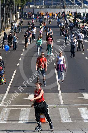 Pedestrians and bicyclists traveling on the Paseo de la Reforma on a Sunday in Mexico City, Mexico.
