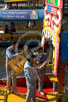 Colorful trajineras travel on the Xochimilco canals within Mexico City, Mexico.