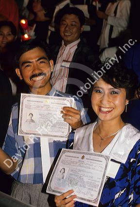 A new american citizens display certificates at a citizenship ceremony in Boise, Idaho.
