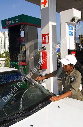 Mexican female attendant pumping fuel at a full service gas station in Acapulco, Guerrero, Mexico.