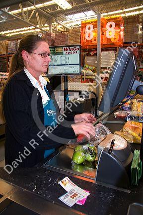 Cashier scanning items and coupons in the checkout line of a supermarket in Idaho, USA.