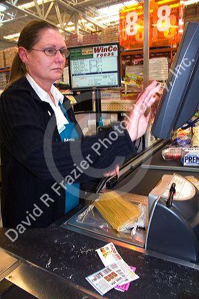 Cashier scanning items and coupons in the checkout line of a supermarket in Idaho, USA.