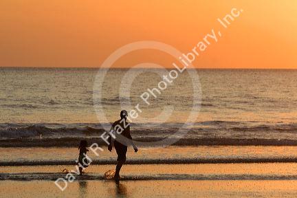 People walk on the beach at sunset in Jaco, Costa Rica.
