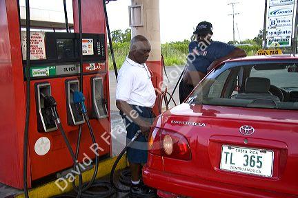 Attendants pump fuel at a gas station in Limon, Costa Rica.