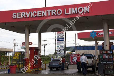 Attendants pump fuel at a gas station in Limon, Costa Rica.