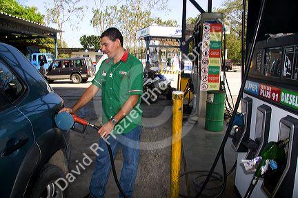Gas station attendant pumping fuel in the town of Jaco, Costa Rica.