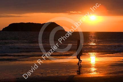 Person walking on the beach at sunset in the Manuel Antonio National Park in Puntarenas province, Costa Rica.