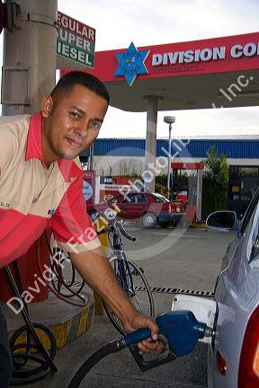 Attendant pumps fuel at a gas station in Limon, Costa Rica.