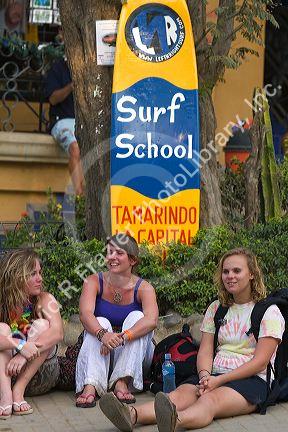Female travelers sit in front of a surf school in the town of Tamarindo on the Northern Pacific Coast of Costa Rica.