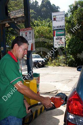 Gas station attendant pumping fuel in the town of Jaco, Costa Rica.