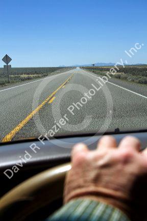 Drivers hand on the steering wheel of an automoble, Oregon, USA.