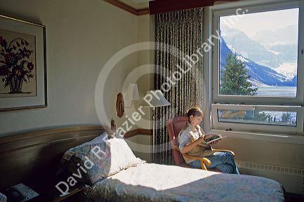 A woman reads in her room in the Chateau at Lake Louise in Banff, Alberta, Canada.