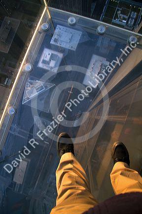 A man's feet on the skydeck of the Willis Tower in Chicago, Illinois, USA.