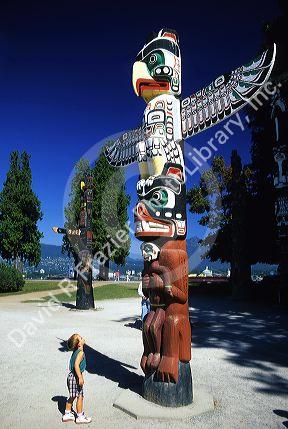 A young boy looks up at a totem pole In Vancouver, Canada.