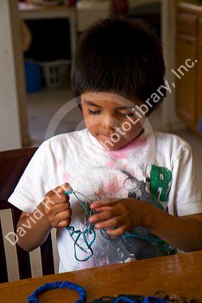 Native Pueblo boy crafting dreamcatchers in San Felipe Pueblo, New Mexico, USA.