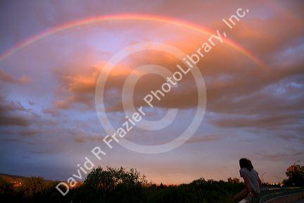 A couple viewing a rainbow at sunset in Boise, Idaho, USA.