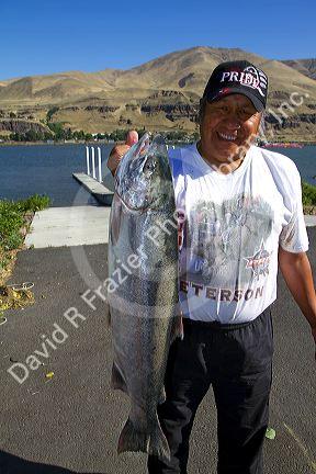 Native American indian displaying a chinook salmon on the Columbia River, Oregon, USA.