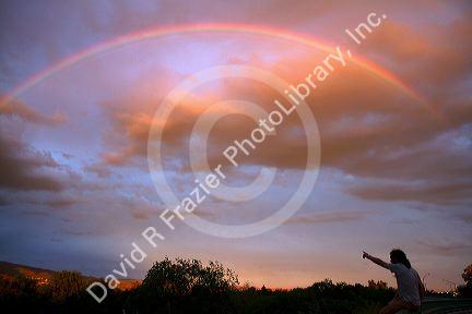 A couple viewing a rainbow at sunset in Boise, Idaho, USA.