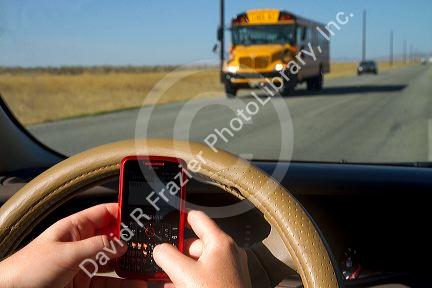 Text messaging on a cell phone while driving in Idaho, USA. MR