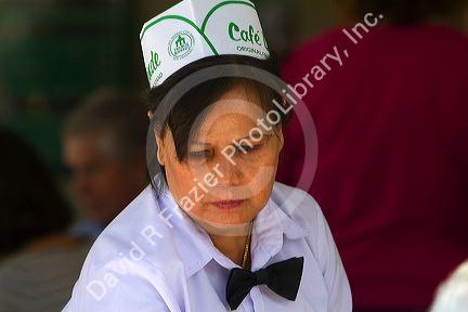Server at Cafe Du Monde in the French Quarter of New Orleans, Louisiana, USA.