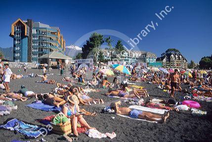 People sunbathing on a black sand beach at Villarica Lake in Pucon, Chile.