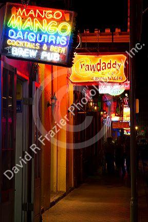 Neon signs of bars and restaurants along Bourbon Street in the French Quarter of New Orleans, Louisiana, USA.