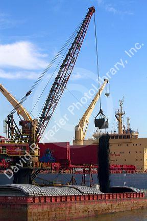 Crane loading a barge with coal on the Mississippi River at New Orleans, Louisiana, USA.
