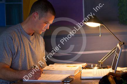 Male student studying a textbook in Boise, Idaho, USA.