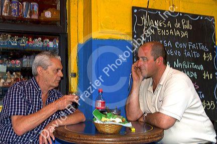 Argentine men dine at a cafe in the La Boca barrio of Buenos Aires, Argentina.