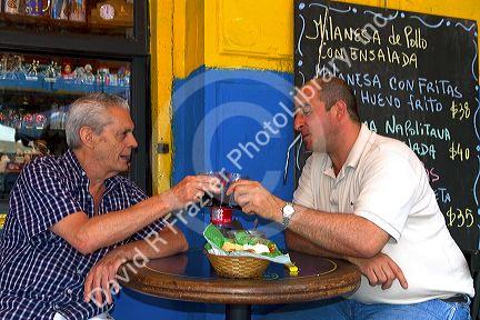 Argentine men dine at a cafe in the La Boca barrio of Buenos Aires, Argentina.