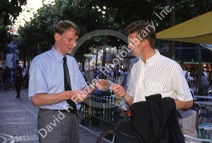 Men greet and exchange business cards on the sidewalk in Germany.