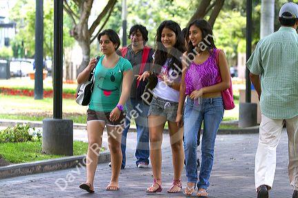 Teenage peruvian girls walking in Central Park of the Miraflores district of Lima, Peru.