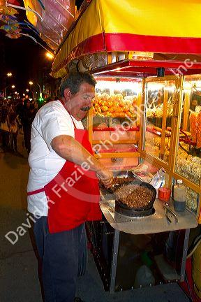 Argentine street vendor making toffee covered nuts at Necochea, Argentina.